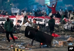 FILE - A supporter of Indonesian presidential candidate Prabowo Subianto throws rock at riot police during clashes in Jakarta, Indonesia, May 22, 2019.