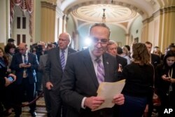 FILE - Senate Minority Leader Sen. Chuck Schumer of N.Y., center, leaves a news conference following a Senate policy luncheon after House and Senate negotiators worked out a border security compromise hoping to avoid another government shutdown on Capitol Hill, Feb. 12, 2019.