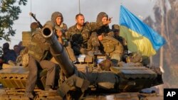 Soldiers of Ukrainian army ride on a tank in the port city of Mariupol, southeastern Ukraine, Sept. 5, 2014.