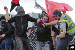 Demonstrators clash with military police during a protest against the approval of the measure to cap government spending over the next 20 years, in Brasilia, Brazil, Dec. 13, 2016.