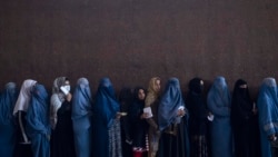 Women line up to receive cash at a money distribution point organized by the World Food Program, in Kabul, Afghanistan, Nov. 20, 2021.