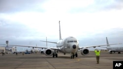 A sailor signals the pilot of a P-8A Poseidon during a preflight check, Oct. 23, 2019, in Oak Harbor, Wash. A Chinese Navy ship fired a laser at a U.S. surveillance aircraft flying over the Philippine Sea west of Guam, the Navy said, Feb. 27, 2020.