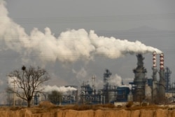 FILE - In this Nov. 28, 2019, photo, smoke and steam rise from a coal processing plant in Hejin in central China's Shanxi province.