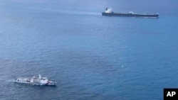 Kapal Badan Keamanan Laut (BAKAMLA), mengawal kapal tanker berbendera Iran, MT Horse (kanan atas), ke arah Pulau Batam, April 2021.