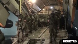 Russian troops disembark from a military aircraft, as part of a peacekeeping mission of the Collective Security Treaty Organisation amid mass protests in Almaty and other Kazakh cities, at an airfield in Kazakhstan. Photo released by Russia's Defense Ministry, Jan. 8, 2022.