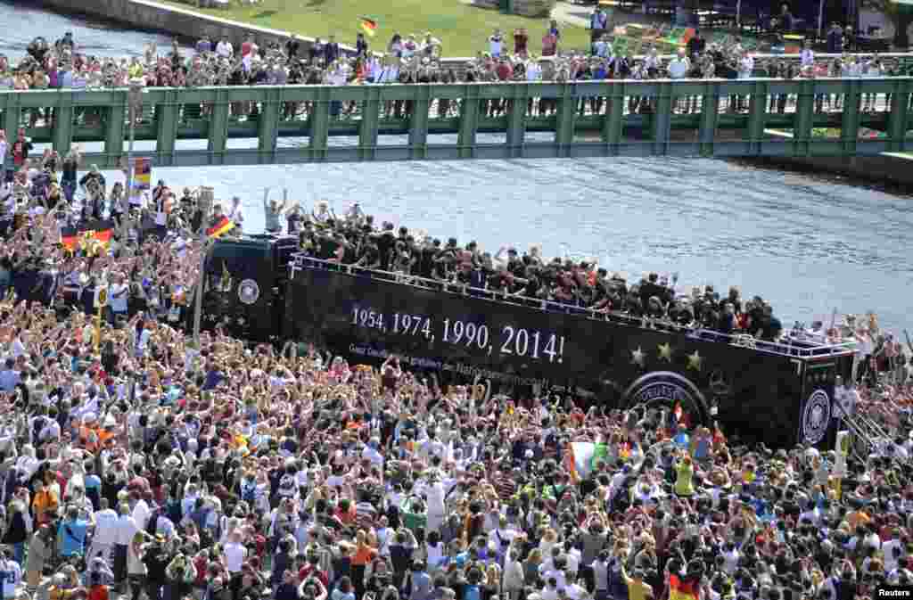 Ribuan warga Berlin melakukan parade bersama tim Jerman yang baru saja menjuarai Piala Dunia 2014 di Brazil.