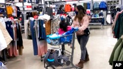 FILE - Consumers shop at a retail store in Vernon Hills, Ilinois., Nov. 13, 2021. The Federal Reserve’s goal in raising its benchmark inflation rate is to curb consumer demand and, correspondingly, curtail inflation.