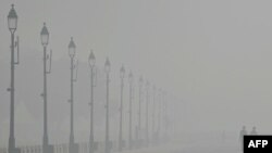 People walk along the Kartavya Path amid heavy smoggy conditions in New Delhi, Nov. 5, 2023.