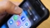 Seorang pria memegang ponsel pintar dengan ikon untuk aplikasi jejaring sosial Facebook, Instagram dan Twitter terlihat di layar di Moskow pada 23 Maret 2018. (Foto: AFP)