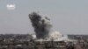 This frame grab from video provided Aug. 13, 2017, by the Ghouta Media Center, a Syrian activist media group, shows smoke and debris rising after a Syrian government ground-to-ground rocket strikes the opposition-held town of Ain Terma, in the Eastern Ghouta suburb of Damascus, Syria. 