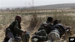 Libyan rebels take their position during a battle against pro-Gadhafi fighters, in the town of Brega, east of Tripoli, March 2, 2011