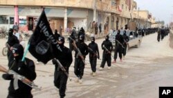 Dalam foto yang ditampilkan dalam website militan pada 14/1/2014 ini, para pejuang ISIL pecahan dari al-Qaida tampak berbaris di Raqqa, Suriah.