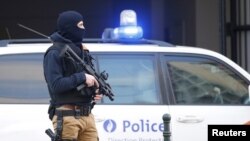 Polisi Belgia sedang berjaga di luar gedung pengadilan saat pelaku serangan Paris ditahan pihak berwenang di Brussels, Belgia (7/4).