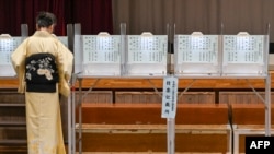 Žena u tradicionalnom kimonu glasa tokom opštih izbora na biračkom mjestu postavljenom u lokalnoj školi u Tokiju 27. oktobra 2024.