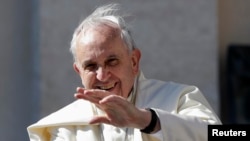 FILE - Pope Francis waves as he arrives to lead his Wednesday general audience in Saint Peter's Square at the Vatican.