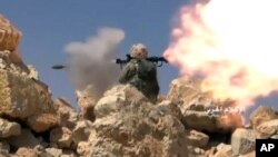 Cuplikan video yang dirilis hari Sabtu, 22 Juli 2017 menunjukkan seorang pejuang Hezbollah menembakkan pelontar granat selama bentrokan dengan militan yang terkait al-Qaida di perbatasan Lebanon-Suriah (foto: Syrian Central Military Media, via AP)
