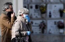 Relatives attend the funeral of a woman who died from coronavirus disease (COVID-19), as Italy struggles to contain the spread of disease, in Seriate, Italy, March 28, 2020.
