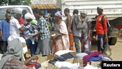 Des familles font la queue dans un centre des Nations Unies pour les réfugiés burundais pour recevoir des rations alimentaires et des vêtements à Uvira, Sud-Kivu, 20 mai 2015.
