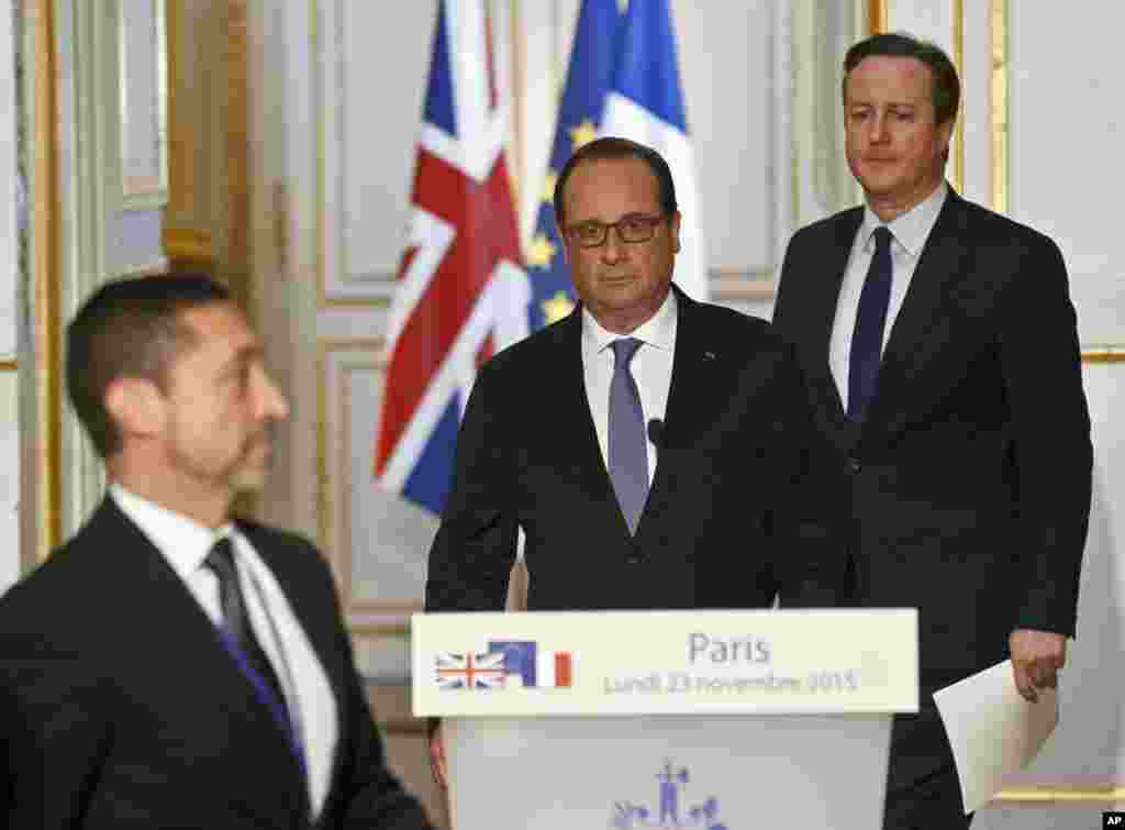 France's President Francois Hollande, left, Britain's Prime Minister David Cameron arrive to issue a joint statement to the media at the Elysee Palace in Paris.