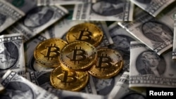 Bitcoin (virtual currency) coins placed on Dollar banknotes are seen in this illustration picture, Nov. 6, 2017. 
