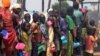 FILE - Refugees in Rwanda wait in lines for food, water, soap and other necessities that are in short supply.