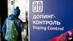 FILE - A man walks past a sign reading "Doping Control" in Russian at a 2014 Sochi Winter Olympics site in Krasnaya Polyana, Russia. Feb. 21, 2014.