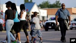 Polisi siaga di kota Ferguson (18/8). Penembakan terakhir di kota St. Louis, Missouri menambah kompleks permasalah di negara bagian Missouri. 