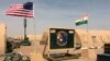 In this photo taken April 16, 2018, a U.S. and Niger flag are raised at the base camp for air forces and other personnel supporting the construction of Niger Air Base 201 in Agadez, Niger. On the edge of the Sahara Desert, the U.S. is building a base for armed drones.