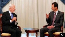 FILE - This SANA photo shows Syrian President Bashar Assad, right, speaking with U.N. envoy Staffan de Mistura in Damascus, Nov. 10, 2014.