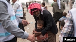 FILE - A displaced boy, who fled the violence in Mosul, receives a measles vaccination from a UNICEF-supported health worker in Hamdaniyah, Iraq, Oct. 24, 2016.