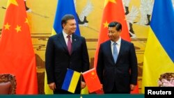 Ukraine's President Viktor Yanukovych (L) and Chinese President Xi Jinping attend a signing ceremony at the Great Hall of the People in Beijing, Dec. 5, 2013.