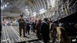 Penumpang Afghanistan menaiki C-17 Globemaster III Angkatan Udara AS selama evakuasi Afghanistan di Bandara Internasional Hamid Karzai di Kabul, Afghanistan. (Foto: Angkatan Udara AS via AP)