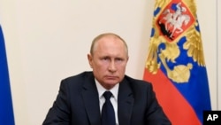 Russian President Vladimir Putin, addresses the nation via video conference at the Novo-Ogaryovo residence outside Moscow, Russia, May 11, 2020.