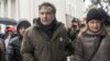 Former Georgian president Mikheil Saakashvili, left, and his wife Sandra Roelofs, right, attend a rally of his supporters as they camp out outside parliament demanding the resignation of the Ukrainian president, in Kiev, Ukraine, Dec. 6, 2017.