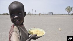 A young boy walks away with his food from a government-sponsored feeding center in central Turkana, Kenya, August 30, 2011