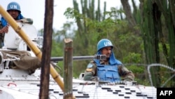 Des Casques bleus patrouillent à bord d'un véhicule blindé sur une route près de Tongo, à quelque 45 km au nord de Goma, Nord-Kivu, 11 mars 2014..