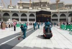 Workers clean the Grand Mosque, during the minor pilgrimage, known as Umrah, in the Muslim holy city of Mecca, Saudi Arabia, March 2, 2020.