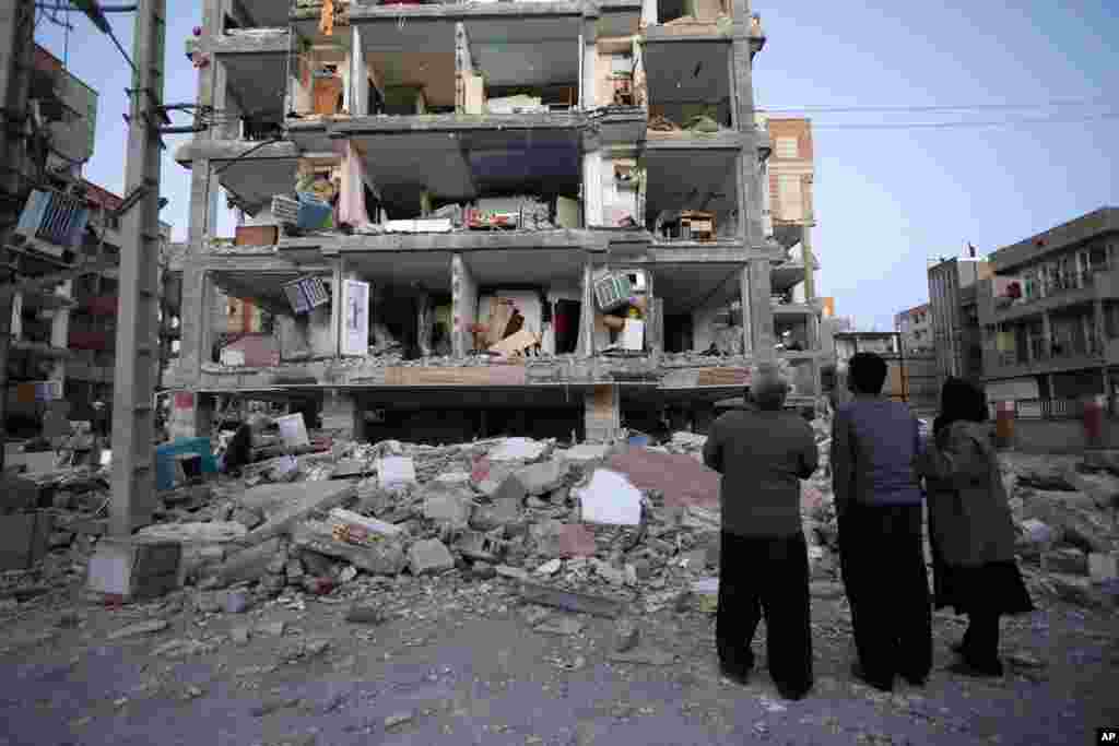 Sur cette photo fournie par l&#39;ISNA, les habitants regardent les bâtiments détruits après un tremblement de terre dans la ville de Sarpol-e-Zahab dans l&#39;ouest de l&#39;Iran, lundi 13 novembre 2017. 
