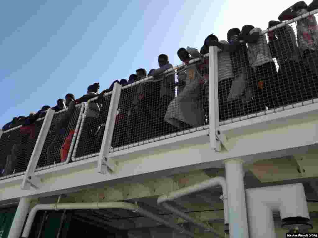 Sous le soleil de Sicile, plus de 500 migrants attendent de debarquer du navire espagnol "Rio Segura", Pozzallo, Sicile, 7 octobre 2015 (Nicolas Pinault/VOA).