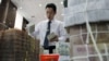 A bank employee stacks Vietnamese dong banknotes at the Vietcombank's headquarters in Hanoi on April 6, 2012. 