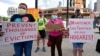 Ljudi drže transparente tokom okupljanja u znak protesta zbog iseljavanja iz kuća, u Bostonu, 9. juna 2021.