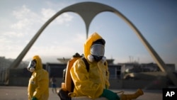 FILE - In this Tuesday, Jan. 26, 2016, photo, a health workers stands in the Sambadrome spraying insecticide to combat the Aedes aegypti mosquito that transmits the Zika virus in Rio de Janeiro, Brazil. The Sambadrome will be the site of the archery competition during the Rio Olympics.