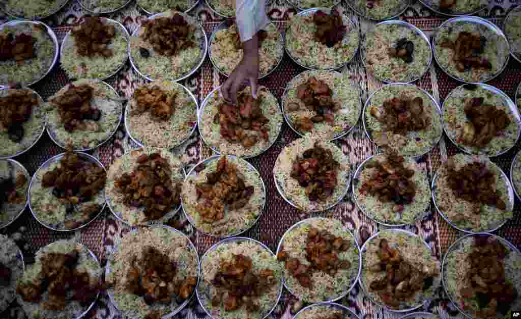 A Pakistani boy arranges plates of food for Iftar, the meal that breaks the day&#39;s fast, during the holy month of Ramadan at a roadside in Islamabad, Pakistan, July 30, 2013.&nbsp;