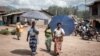 Des femmes déplacées par l'éruption du volcan Nyiragongo marchent dans la rue à Minova, à 50 kilomètres au sud de Goma, la capitale provinciale du Nord-Kivu, le 2 juin 2021.