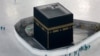 FILE - Workers disinfect the grounds around the Kaaba, a cubic building at the Grand Mosque in the Muslim holy city of Mecca, Saudi Arabia, March 7, 2020.