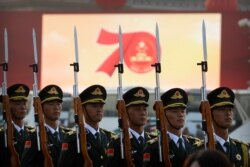 FILE - Members of a Chinese military honor guard stand at attention during a rehearsal before a parade to commemorate the 70th anniversary of the founding of Communist China, in Beijing, Oct. 1, 2019.