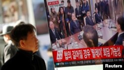 A man watches a TV broadcasting a news report on a high-level talks between the two Koreas at the truce village of Panmunjom, in Seoul, South Korea, Jan. 9, 2018. 