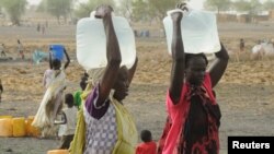 FILE - Internally displaced women carry water from a borehole at a camp near Kodok, in the north-eastern South Sudanese state of Western Nile, April 17, 2017.