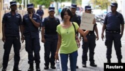A supporter of presidential candidate Mohamed Nasheed, who was ousted as president in 2012, holds up a placard during a protest against the Maldives police, in Male, Oct. 19, 2013. 