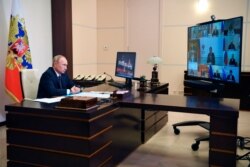 Russian President Vladimir Putin attends a cabinet meeting at the Novo-Ogaryovo residence outside Moscow, Aug. 11, 2020. Putin says that a coronavirus vaccine developed in the country has been registered for use.